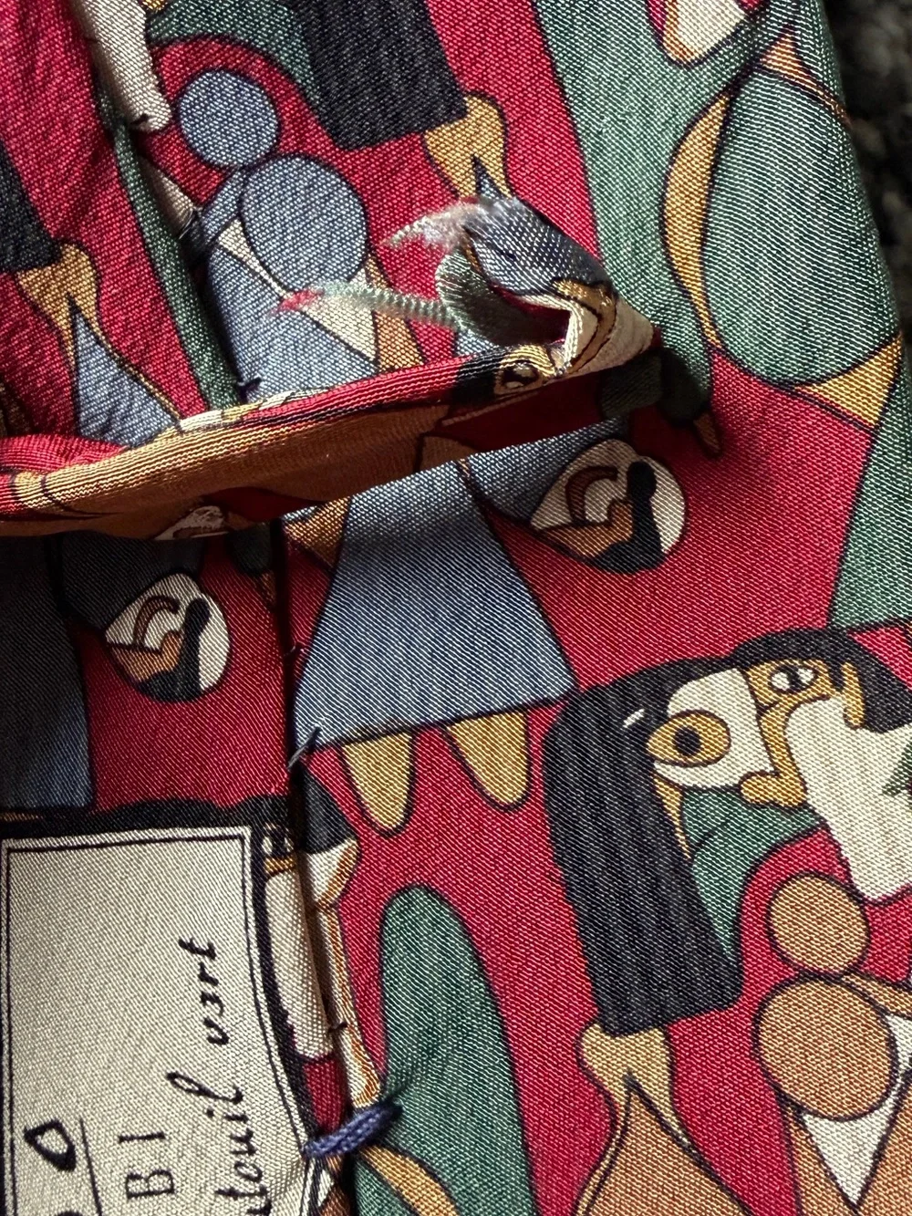 silk tie with abstract geometric pattern in red, green, and brown